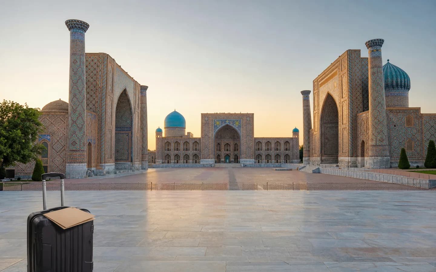 Medical travel documents and luggage at Registan Square in Samarkand, Uzbekistan