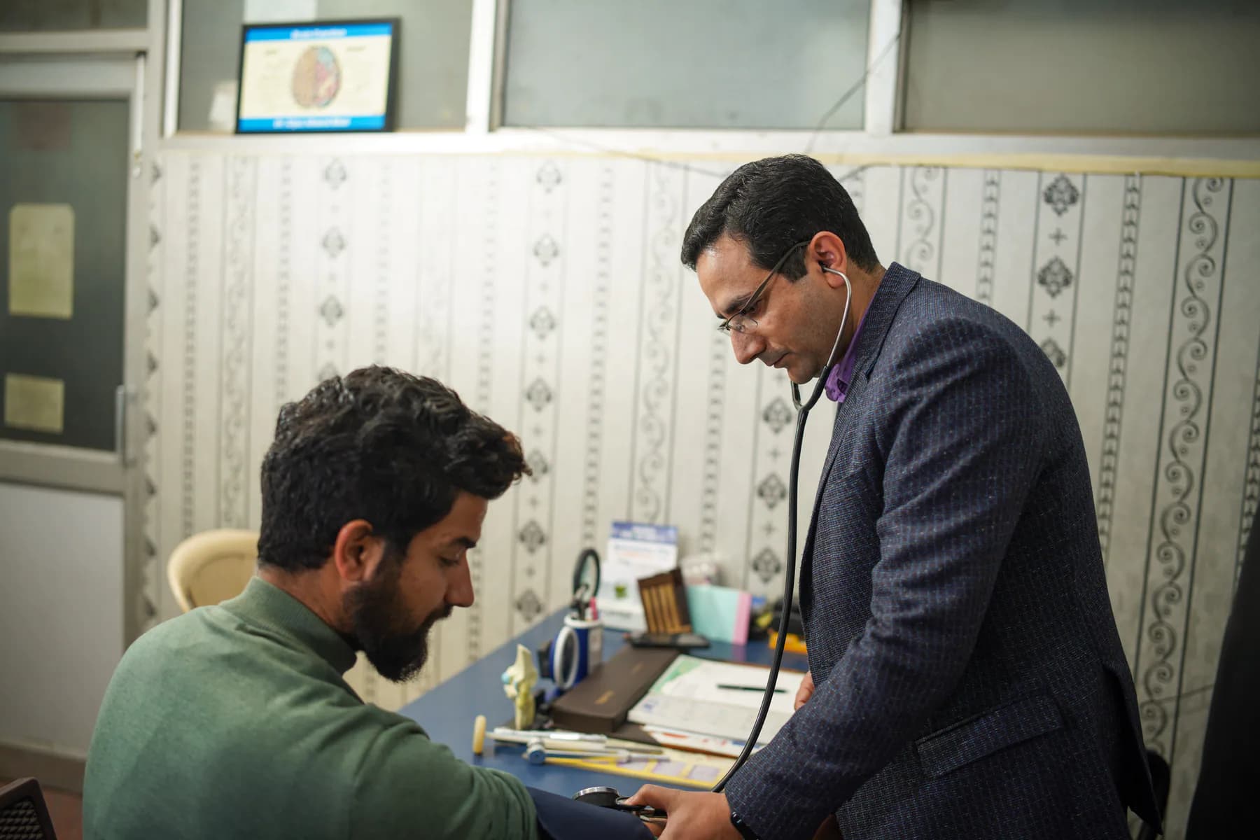 A doctor in India examining a patient during a consultation
