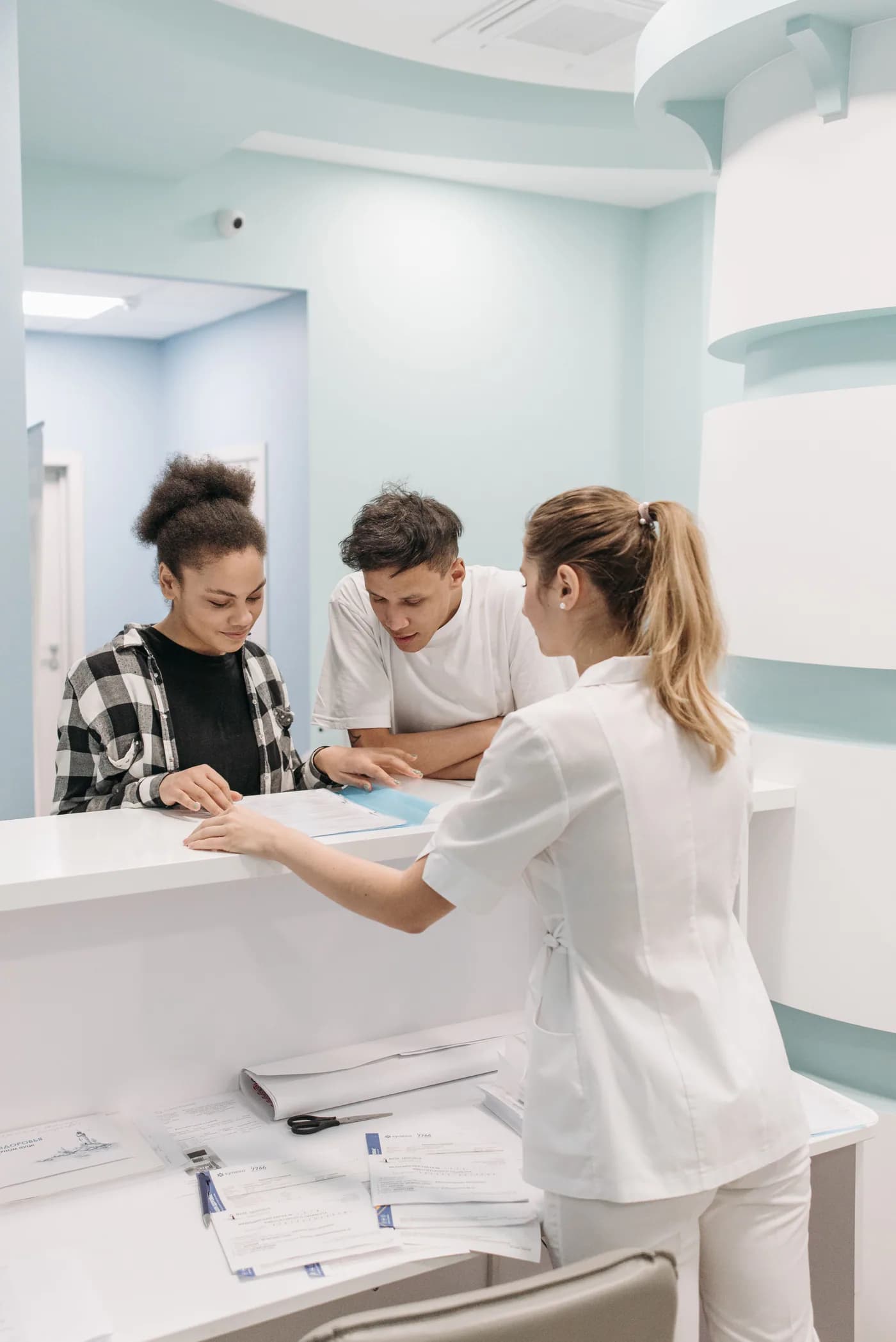 International patients receiving help at a hospital reception desk