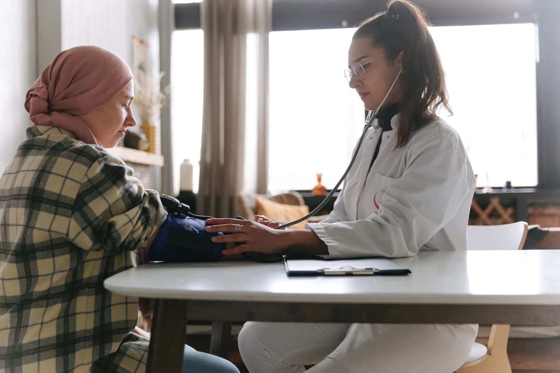 A doctor checking an international patient's blood pressure
